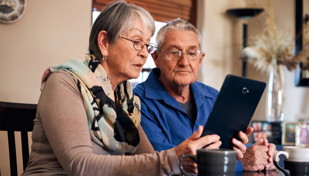 A man and woman looking at a tablet screen