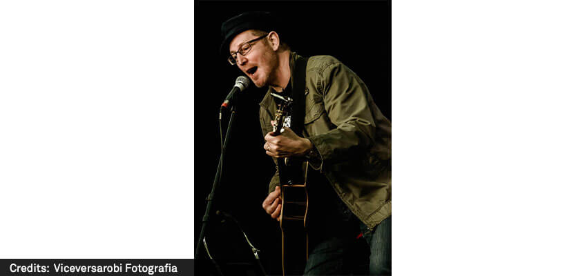 Henry Priestman playing guitar and singing