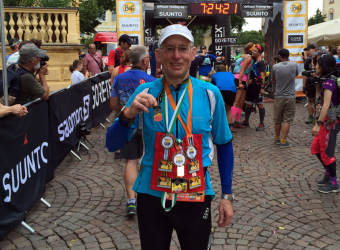 Brain haemorrhage survivor Neil Rhodes with medal after completing a Trans-Alpine run