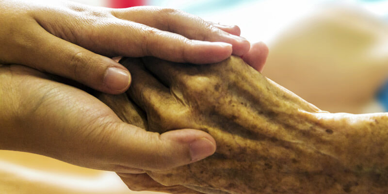Young person holding old person's hands