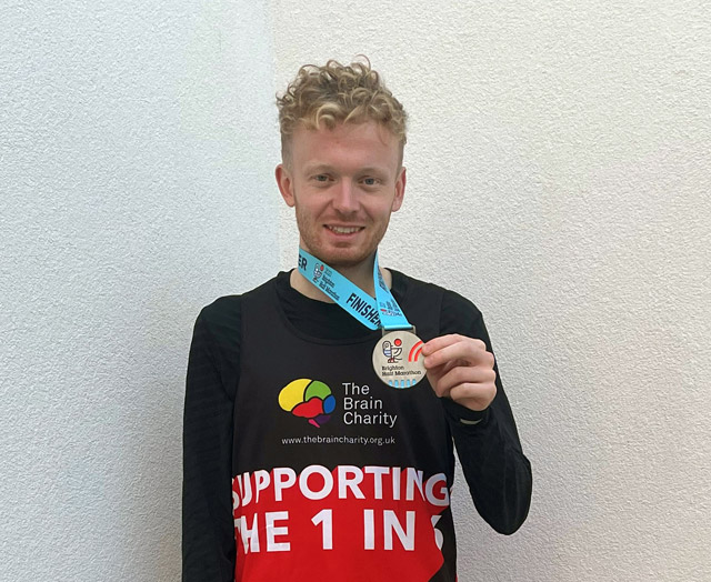 A sponsored runner for The Brain Charity with medal