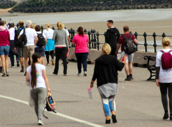 Walkers on the Wirral Coastal Walk. Join The Brain Charity this year.