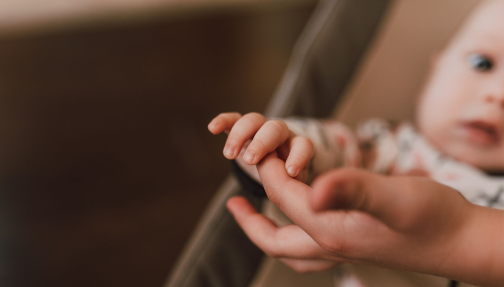 Baby holding mother's hand