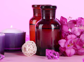 A picture of candles, aromatherapy oils and flowers
