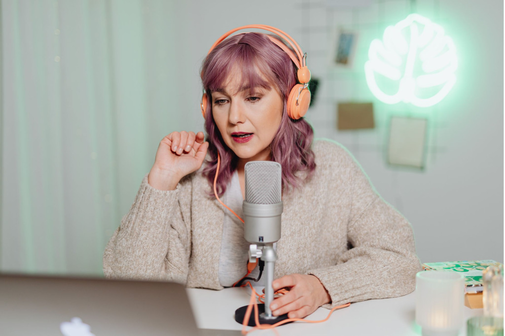 Woman with microphone and laptop making a podcast