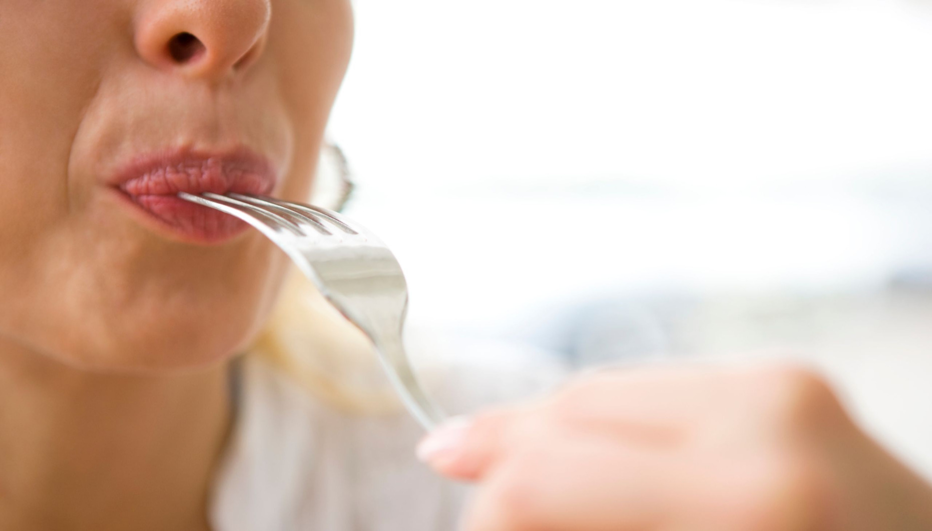Photo of woman eating food from a fork