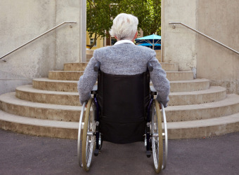 Man in wheelchair facing stairs