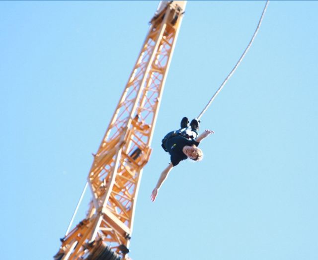 A fundraiser in a Brain Charity T Shirt bungee jumping from a crane