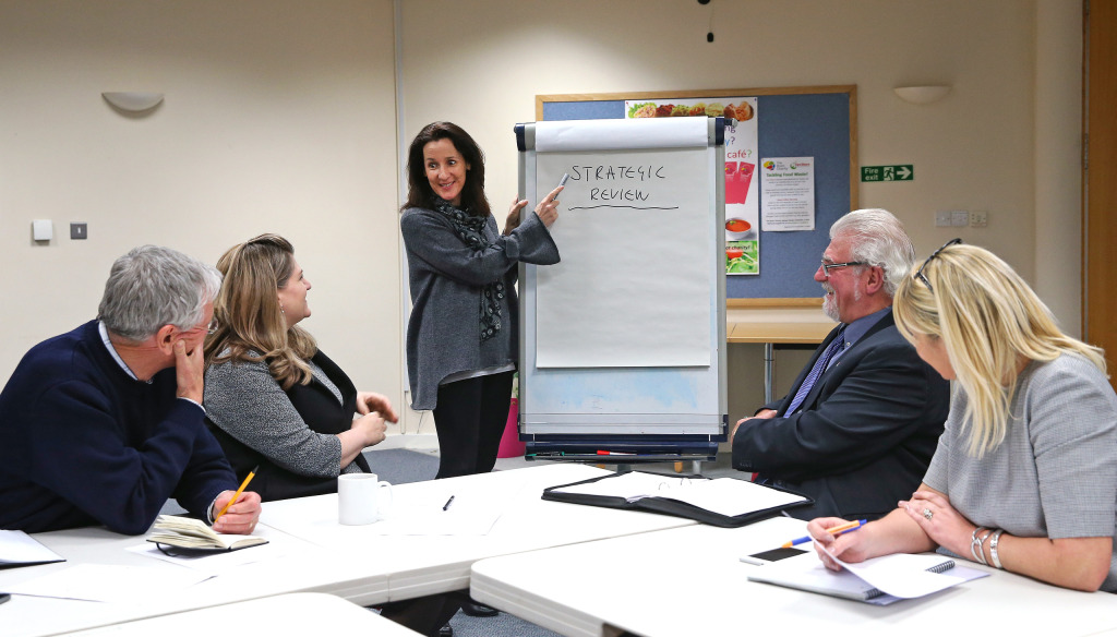 Woman giving a professional business presentation in a meeting with Brain Charity staff