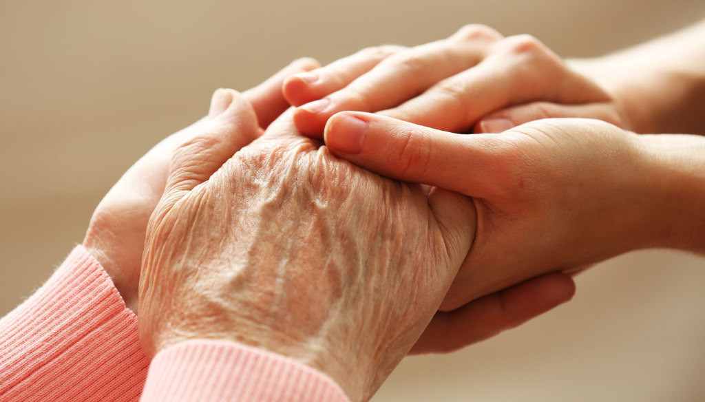 Young person holding old person's hands