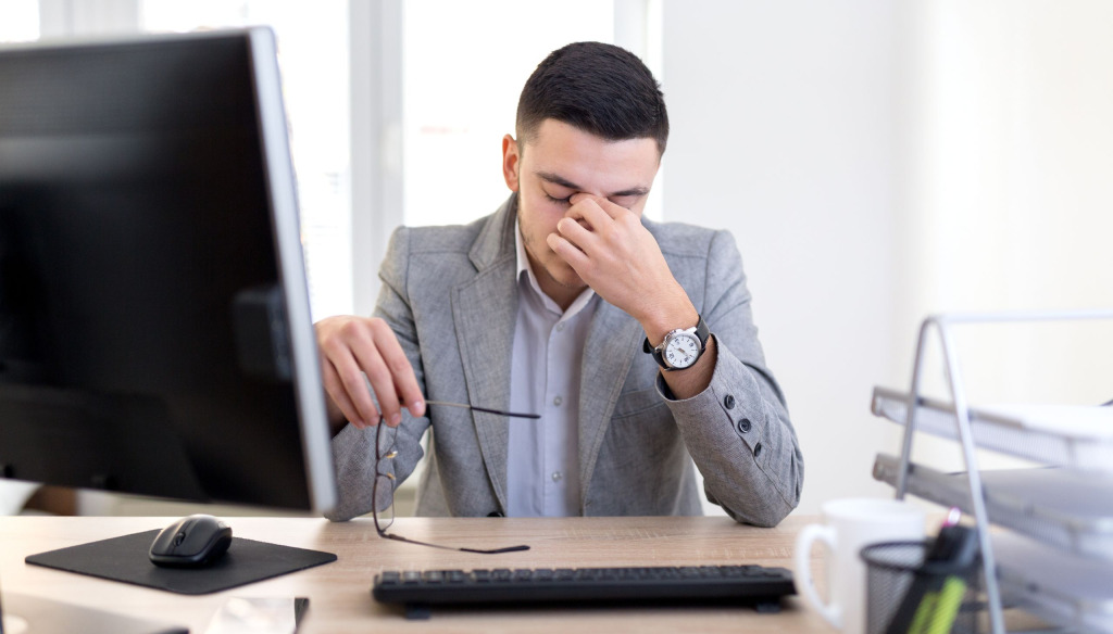 Man experiencing a headache in the office