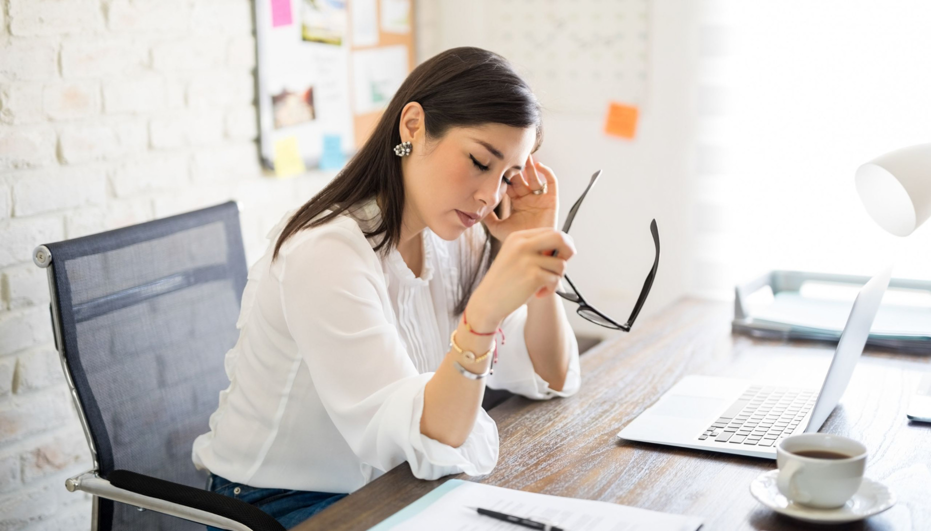 Woman experiencing a headache in the office