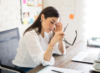 Woman experiencing a headache in the office