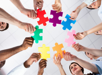 Neurodiversity - a circle of people each holding their own unique puzzle piece