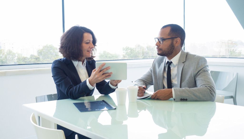 Manager discusses a work project with employee in an office