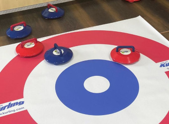 A new age kurling mat with pucks in play