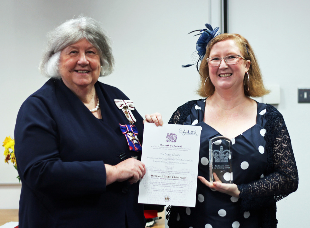 A volunteer receivies the Queen's Award on behalf of The Brain Charity