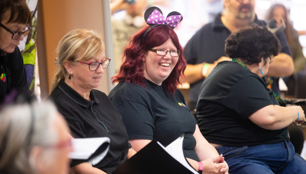 Members of The Brain Charity's sing and a social group seated, smiling.