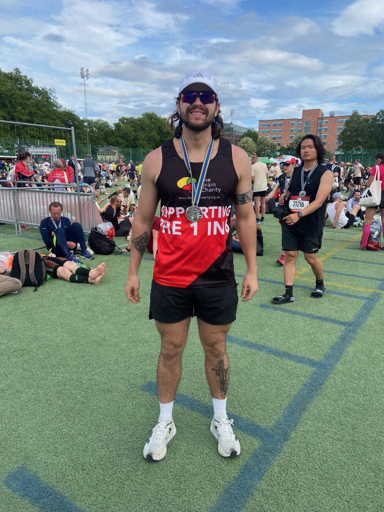 Fundraiser Rafael wearing his Brain Charity running shirt and shorts, along with is finishers medal at the Stockholm race