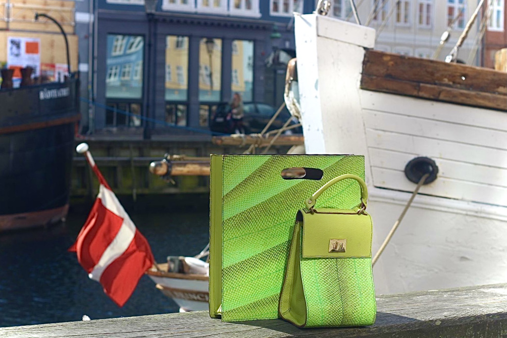 A green Moray Luke handbag and shopper on the dockside with boats in the background