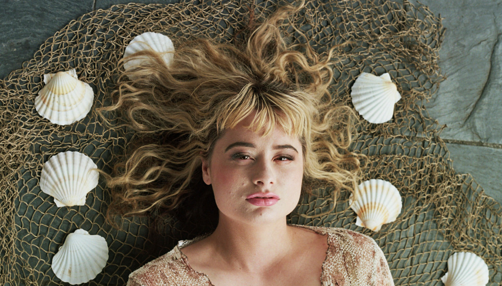 Designer Moray Luke photographed against a background of a fishing net and sea shells as a nod towards her influences