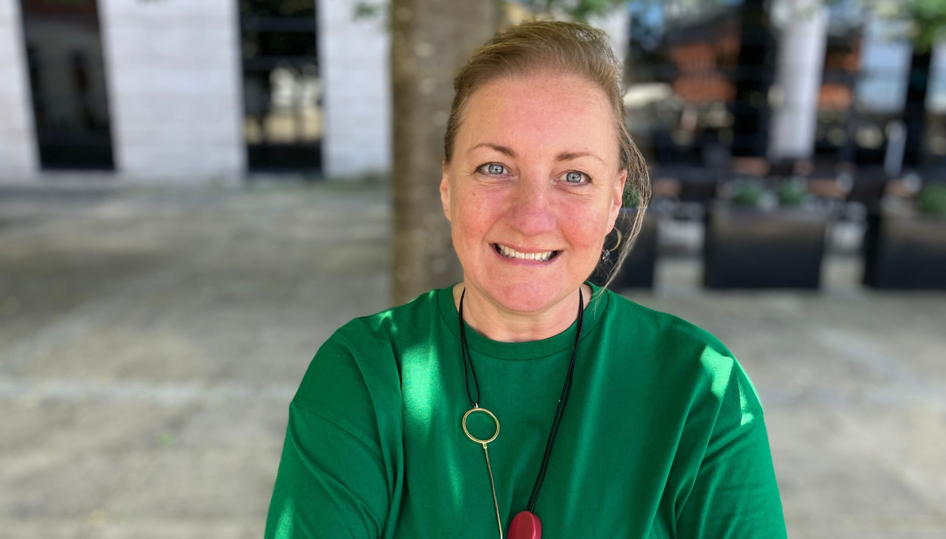 Pippa Sargent, wearing a green top with hair tied back, smiling at camera