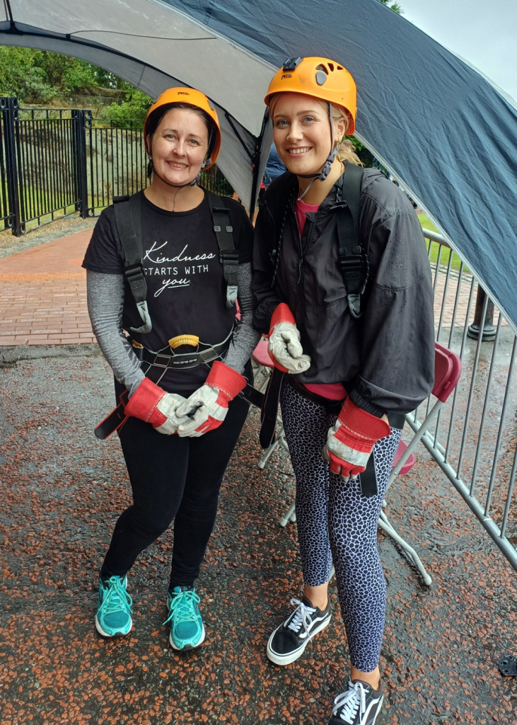 Fundraisers Julie and Tara wearing harnesses, helmets and gloves before their abseil