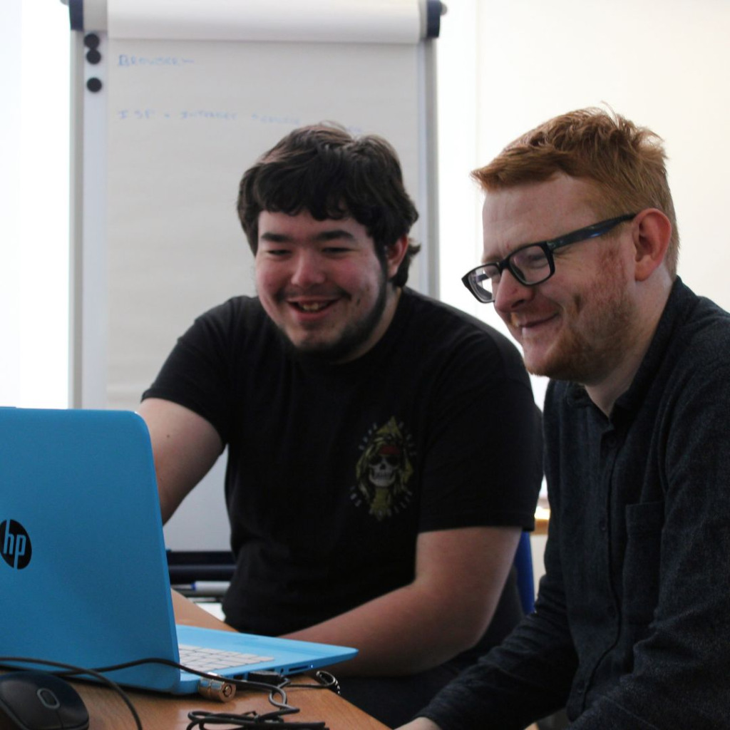 Corporate volunteer having fun sharing his computer skills at The Brain Charity