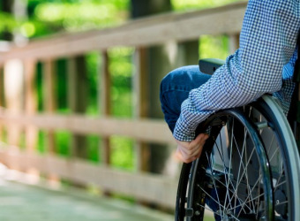 A person in a wheelchair going down a boardwalk