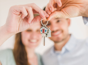 A young couple holding house keys