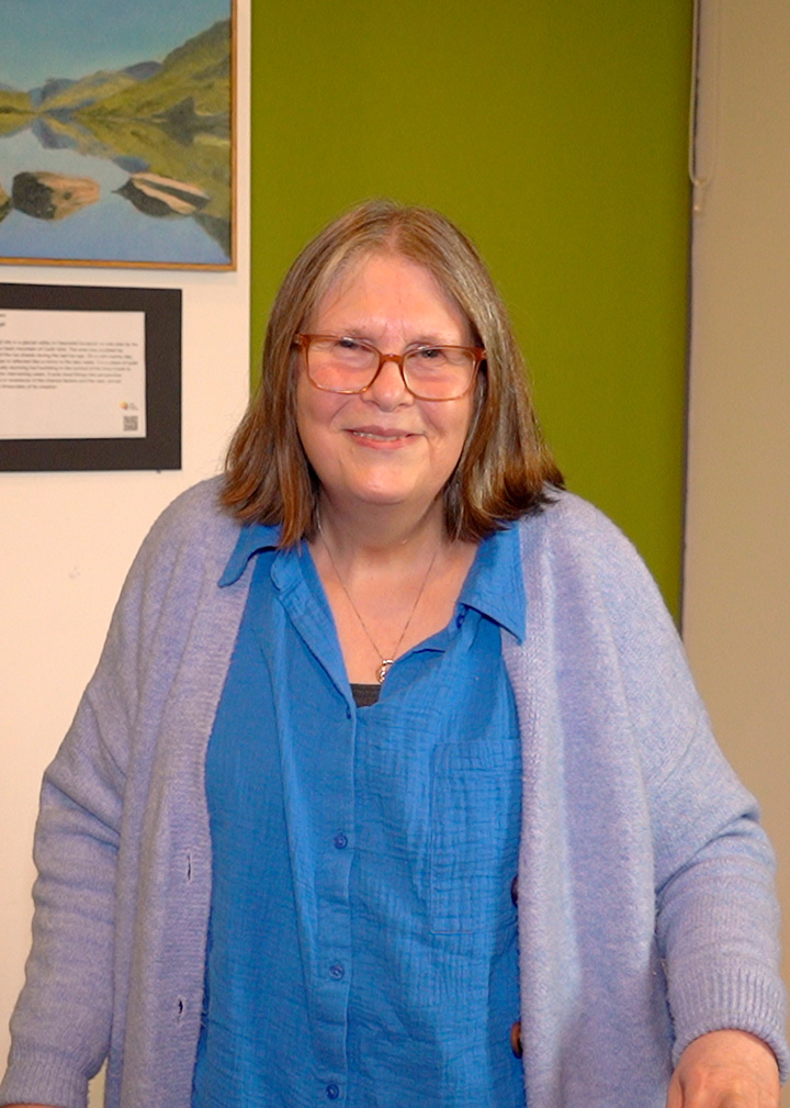 Christine standing in a meeting room at The Brain Charity.