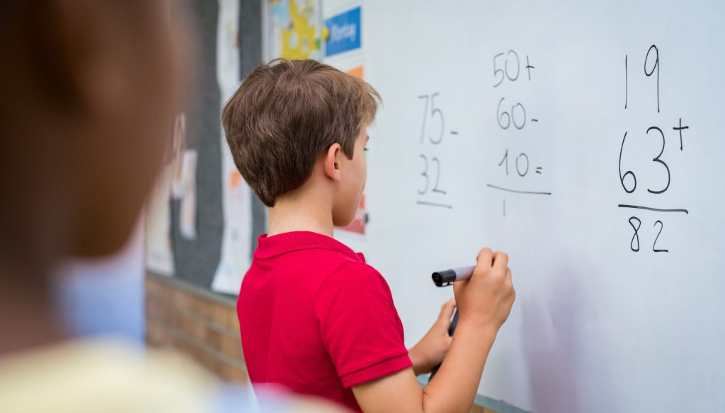 Boy doing calculation on whiteboard