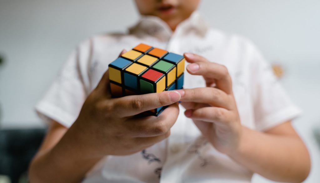 A child solving a Rubick's Cube puzzle