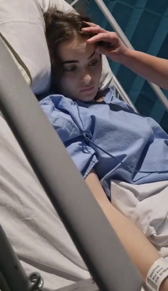 Aisha having a check up in a hospital bed.