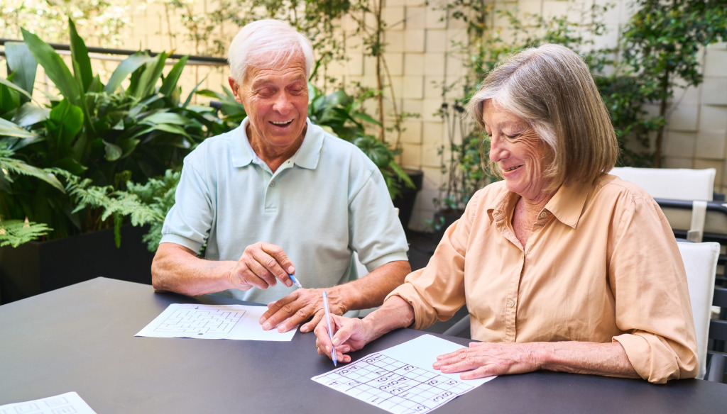 An older man and woman working on a number puzzle