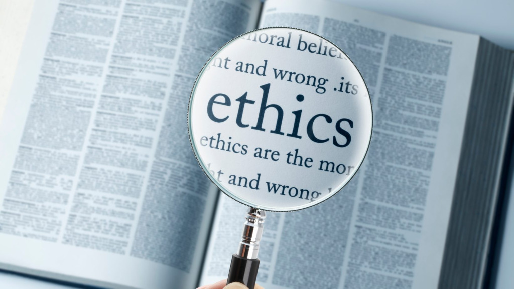A magnifying glass held over the word ethics in a dictionary