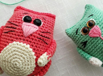 Two small crocheted birds lying on a table
