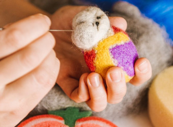 Close up of hands making a felt decoration