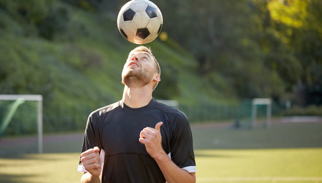Man heading a ball on a training pitch