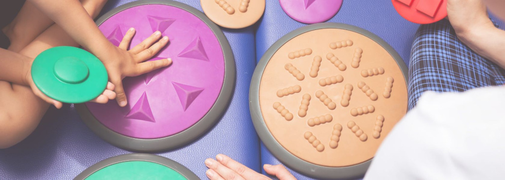 Children touching textured shapes