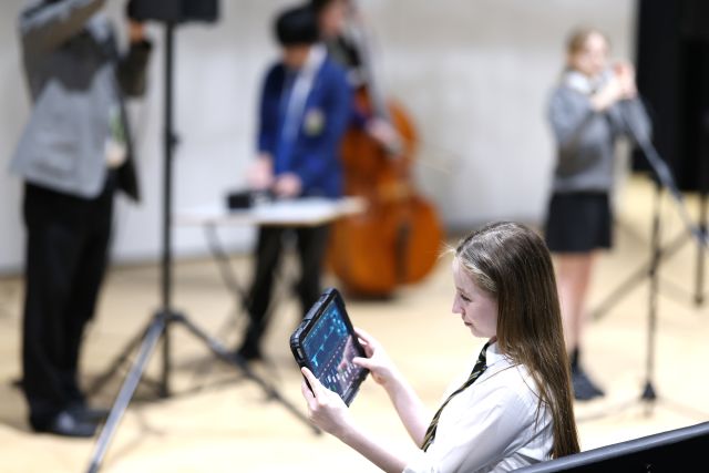A group of young people some playing music and one being a sound engineer