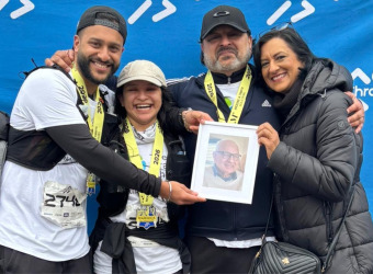 The Bains family posing with a photo of their grandfather.