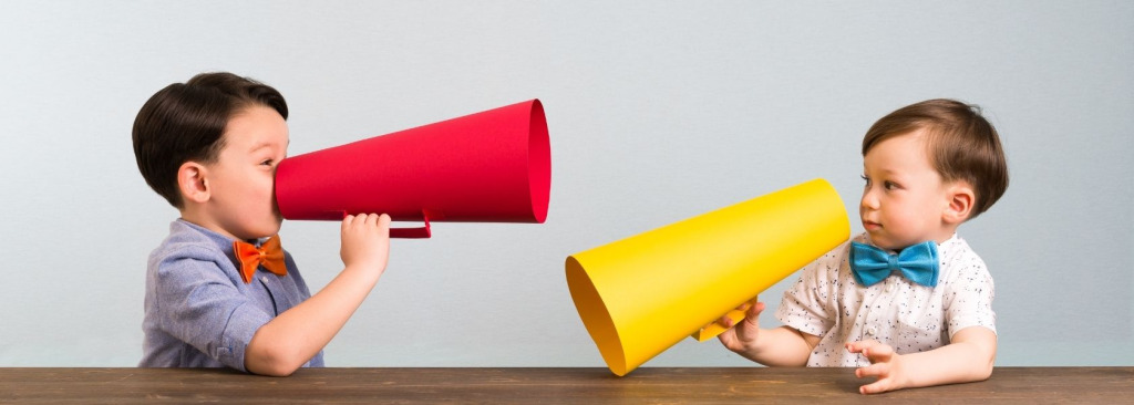 Two boys with megaphones, one is speaking while the other listens