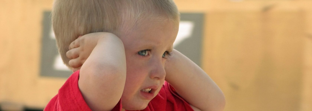Boy covering his ears with his hands