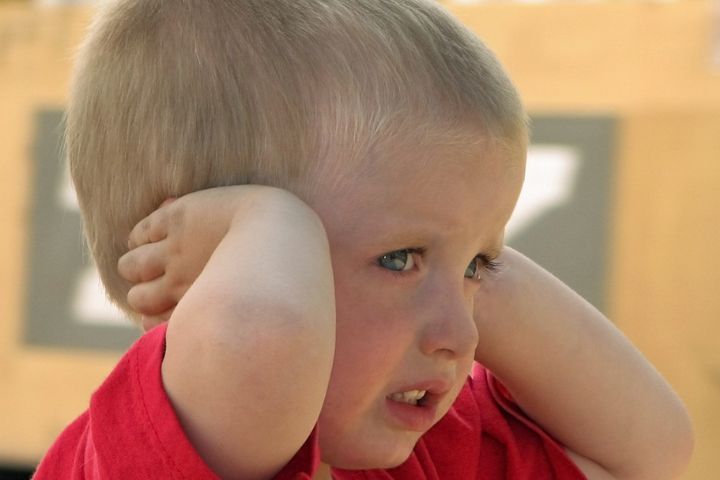 Boy covering his ears with his hands