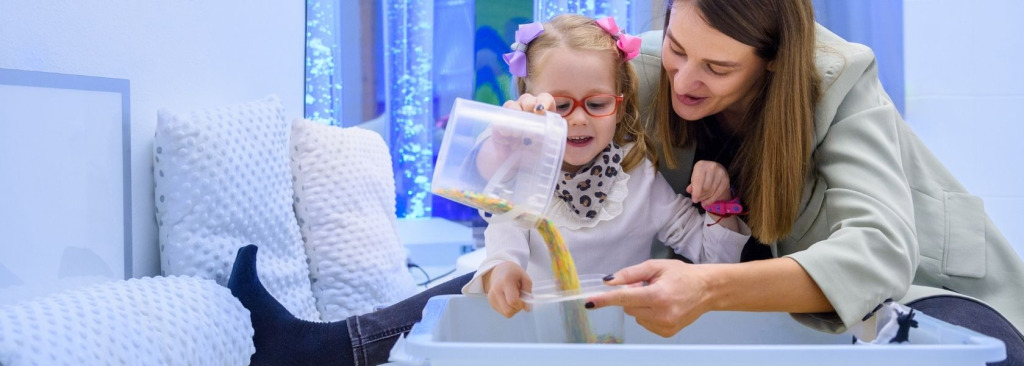 A woman and child playing in a sensory room