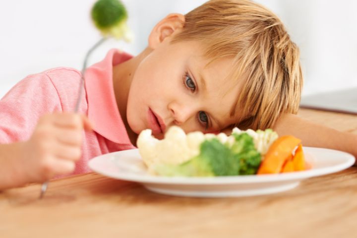 Boy looking at a plate of food