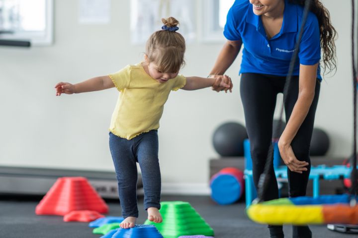 young girl walking over a colourful obstacle course of different sized steps