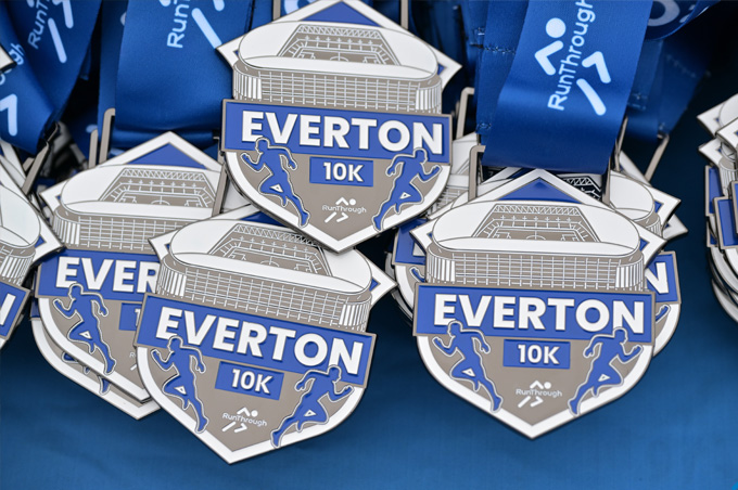 Stacks of Everton 10k finishers medals on a table