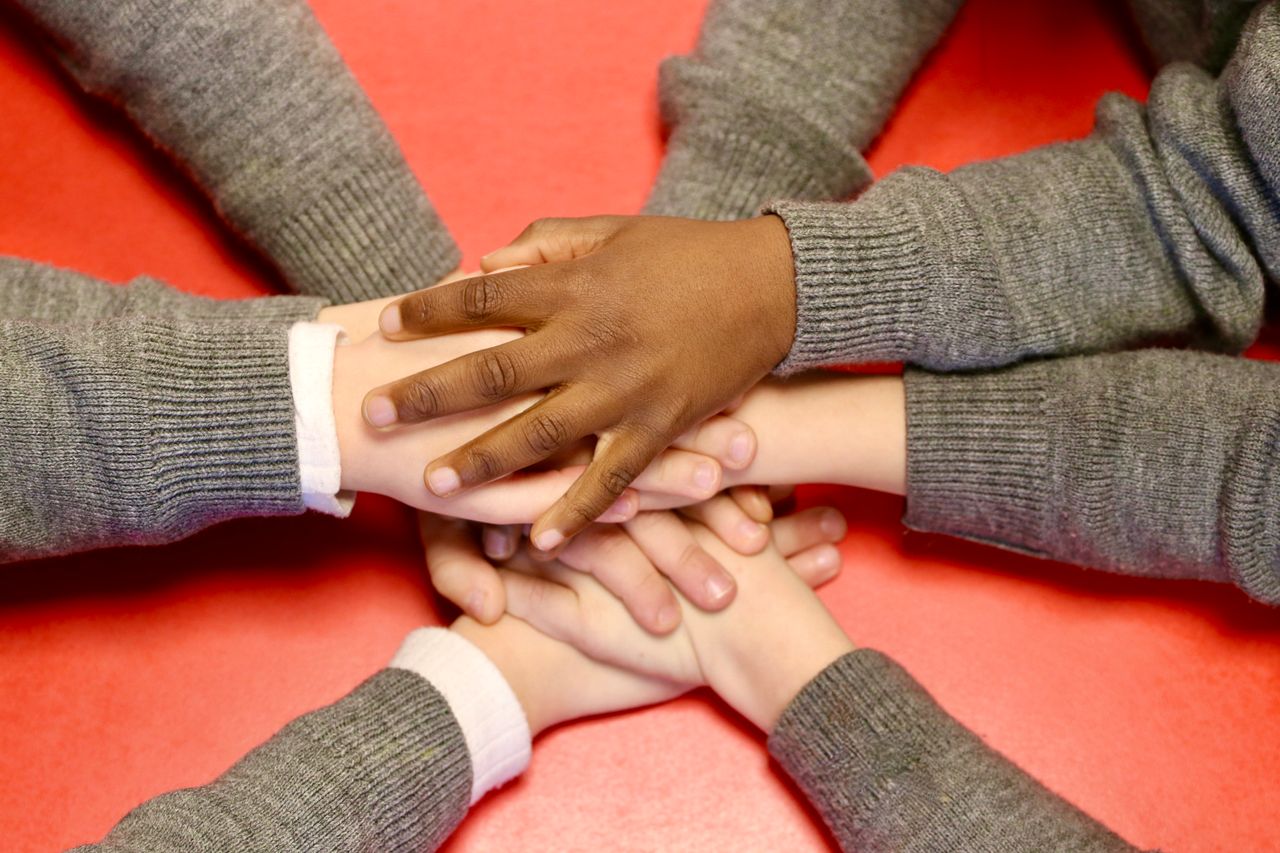 Hands laid atop one another.